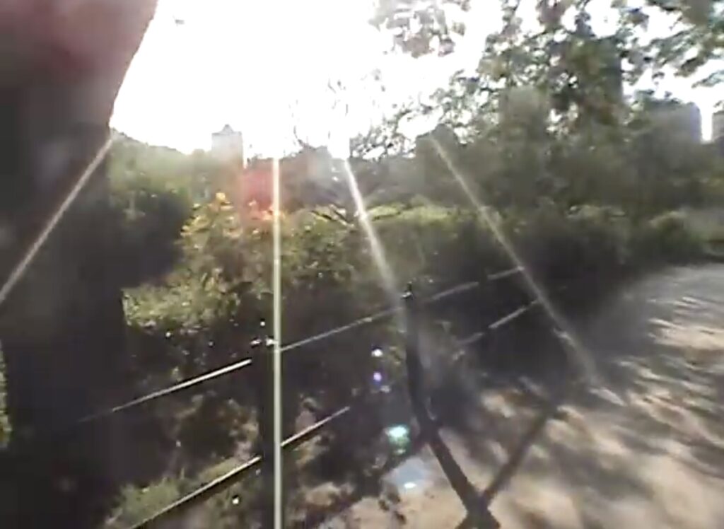 A lens-flared screenshot of a low-res digital video taken on the trail at a Chicago waterfront park.