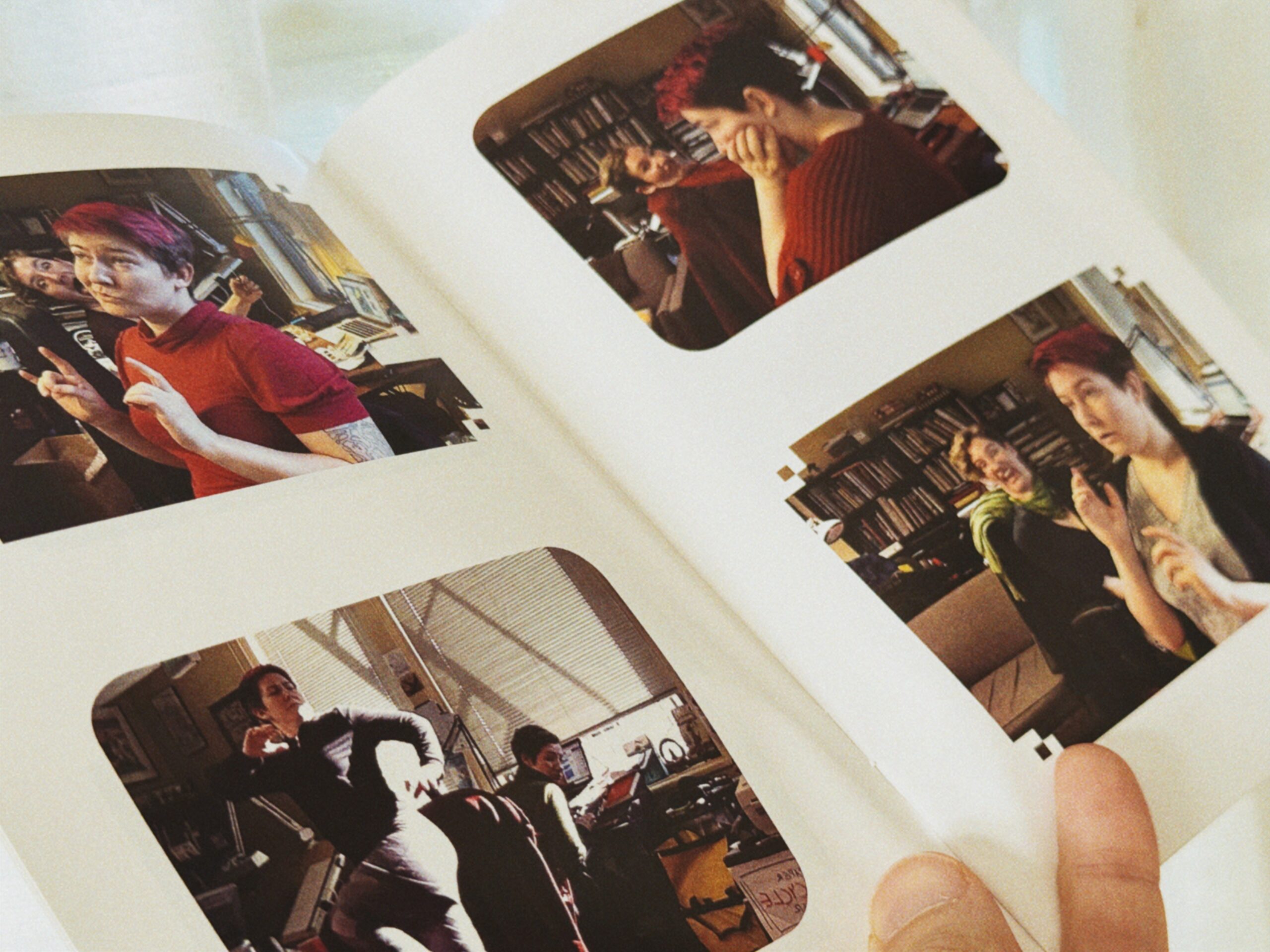 An open copy of the Bombshells zine, showing four pictures of Erika posing while Lucy makes faces behind her.